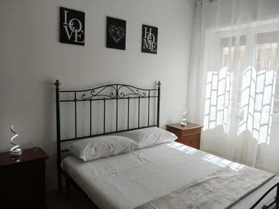 a bedroom with a bed with white sheets and a window at House For You in Rome