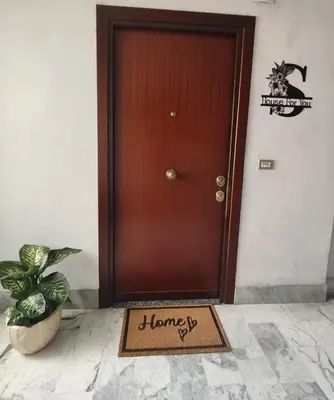 a welcome mat in front of a brown door at House For You in Rome