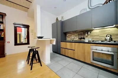a kitchen with stainless steel appliances and wooden cabinets at Apartment Vespucci in Rome