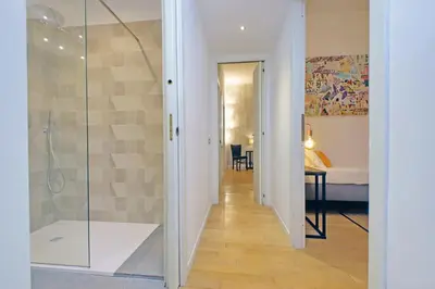 a bathroom with a glass shower and a bedroom at Apartment Vespucci in Rome