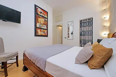 a bedroom with a large white bed and a chair at Apartment Vespucci in Rome
