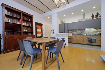 a kitchen with a wooden table and blue chairs at Apartment Vespucci in Rome
