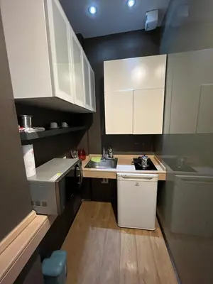 a small kitchen with white cabinets and a sink at Colosseum Vibes in Rome