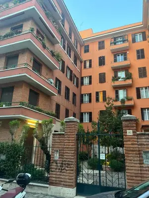 an apartment building with a fence in front of it at Colosseum Vibes in Rome