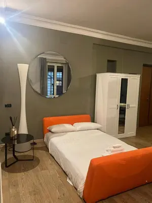 a bedroom with an orange bed and a mirror at Colosseum Vibes in Rome