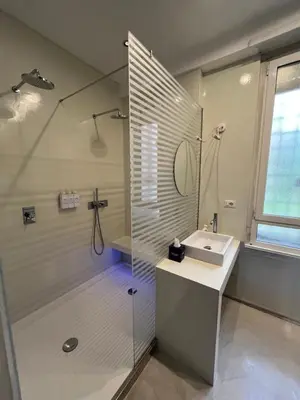a bathroom with a shower and a sink and a mirror at Colosseum Vibes in Rome