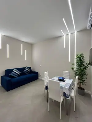 a living room with a blue couch and a table and chairs at Niva holiday house in Rome