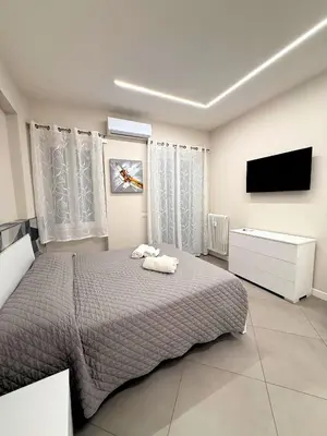 a bedroom with a bed and a flat screen tv at Niva holiday house in Rome