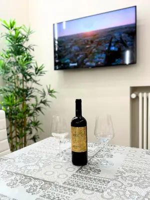 a bottle of wine sitting on a table with two wine glasses at Niva holiday house in Rome