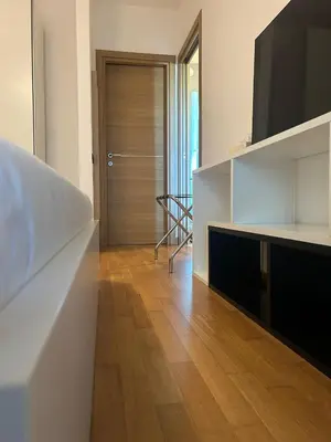 a living room with a television and a wooden floor at Dina Suite Rome in Rome