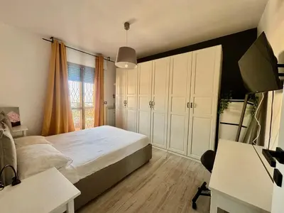 a bedroom with a large bed and a desk at Cozy Apartment with Metro Link to the Colosseum in Rome