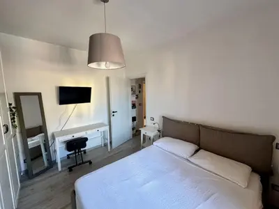 a bedroom with a white bed and a desk at Cozy Apartment with Metro Link to the Colosseum in Rome