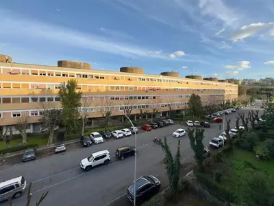 a large building with cars parked in a parking lot at Dylan Apartment in Rome