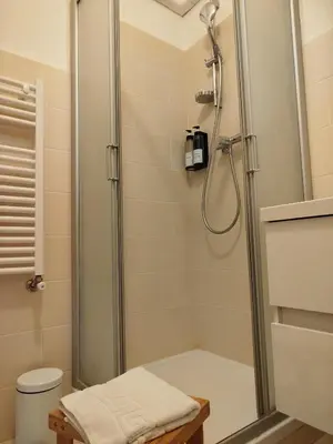 a shower in a bathroom with a glass shower stall at Dylan Apartment in Rome