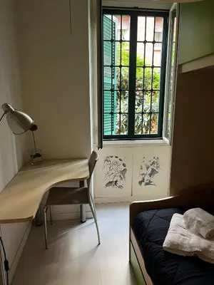 a bedroom with a bed and a window and a desk at Procida's House by ACS HOLIDAYS in Rome