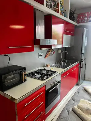 a kitchen with red cabinets and a stove at Procida's House by ACS HOLIDAYS in Rome