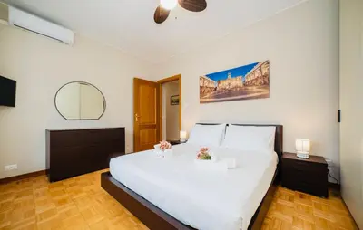 a bedroom with a large white bed with flowers on it at Domusky Attico - 8 piano in Rome