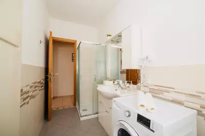 a bathroom with two sinks and a washing machine at Domusky Attico - 8 piano in Rome