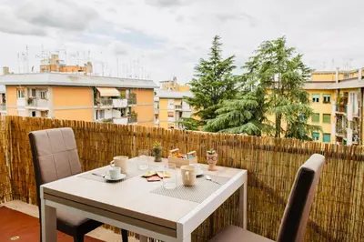 a white table and chairs on a balcony at Domusky Attico - 8 piano in Rome
