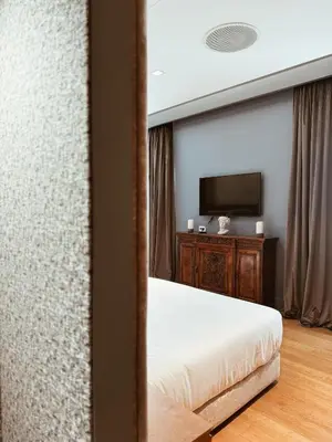 a bedroom with a bed and a flat screen tv at Residenza Imperiale - Luxury Guest House in Rome