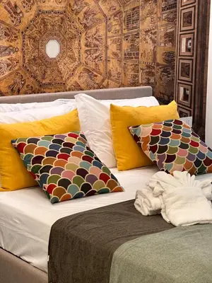 a bed with colorful pillows on top of it at Suite dolce vita - san pietro in Rome