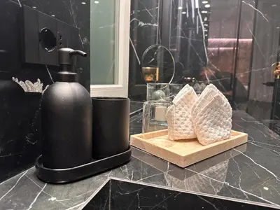 a black soap dispenser sitting on a counter in a bathroom at Suite dolce vita - san pietro in Rome
