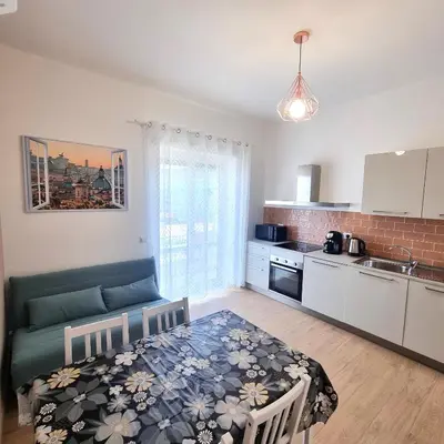 a kitchen with a couch and a table in a room at Suite Station Tiburtina in Rome