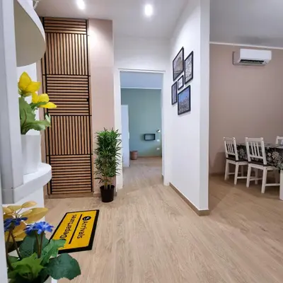 a living room with a hallway with a yellow rug at Suite Station Tiburtina in Rome