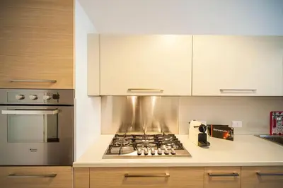 a kitchen with a stove top oven and white cabinets at Great Apartment in great Location in Rome