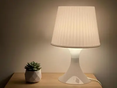 a white lamp sitting on a table with a plant at Suite Mario - Colosseo in Rome