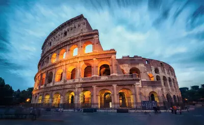 a large building with the light shining on it at Suite Mario - Colosseo in Rome