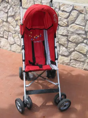 a red stroller sitting on a brick floor at Matteo al Vaticano Vicino Metro in Rome