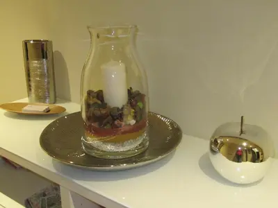 a candle in a glass vase on a plate at Matteo al Vaticano Vicino Metro in Rome