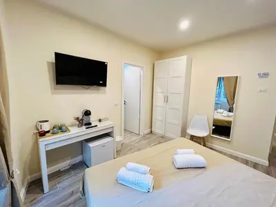 a bedroom with a bed and a tv on the wall at Domus Altino in Rome