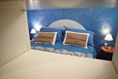 a bedroom with a blue bed with two pillows at La Casetta di Zio Mario in Rome