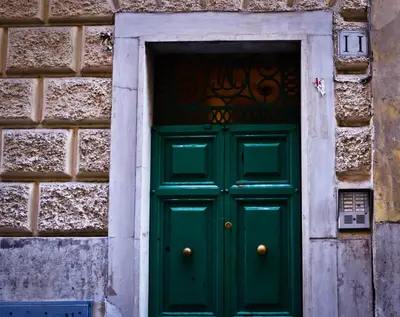 a green door in a stone wall at La Casetta di Zio Mario in Rome