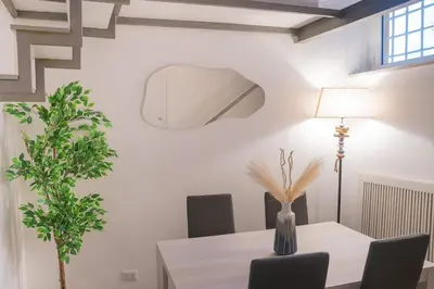 a dining room with a table and a lamp at Maison Campo De Fiori in Rome