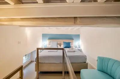 a bedroom with a bed with blue pillows at Maison Campo De Fiori in Rome