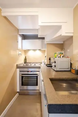 a kitchen with white cabinets and a microwave at Maison Campo De Fiori in Rome