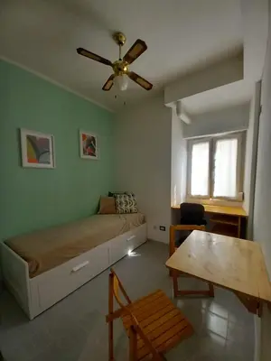 a bedroom with a bed and a ceiling fan at Studio Salvia & Rosmarino in Rome