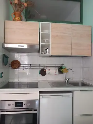 a kitchen with white appliances and wooden cabinets at Studio Salvia & Rosmarino in Rome