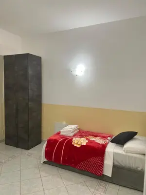 a bedroom with a bed with a red blanket at SALENTINI APPARTAMENTo in Rome