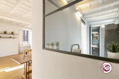 a mirror on a wall in a living room at C M Fori Imperiali Apartment in Rome