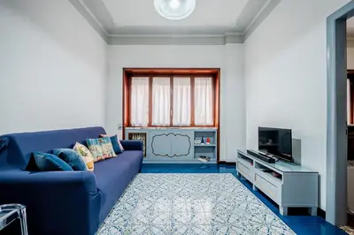a living room with a blue couch and a tv at Guinera Guest House in Rome