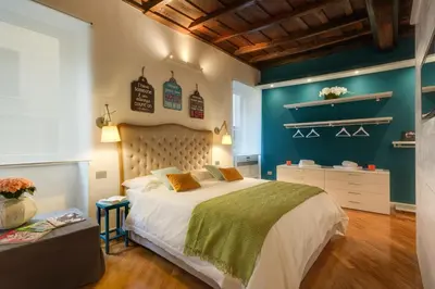 a bedroom with a bed and a blue wall at RHOMENJOY Open Space Colosseo in Rome