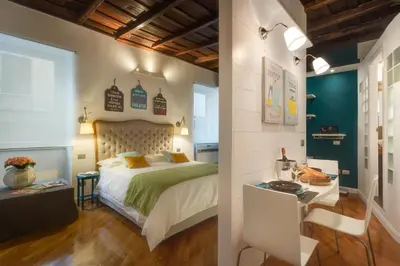 a bedroom with a bed and a desk in a room at RHOMENJOY Open Space Colosseo in Rome