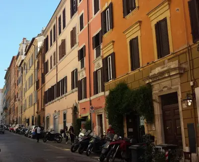 a row of motorcycles parked on a street next to buildings at RHOMENJOY Open Space Colosseo in Rome