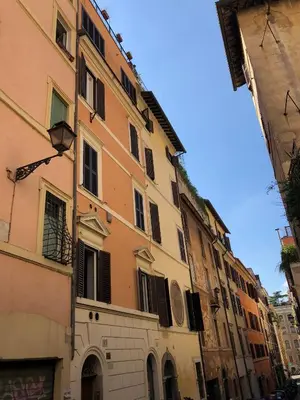 a tall building with windows on a street at RHOMENJOY Open Space Colosseo in Rome