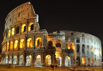 a view of the colosseum at night at RHOMENJOY Open Space Colosseo in Rome