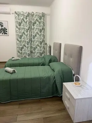 a bed with a green comforter in a room at Roma nel Mondo in Rome